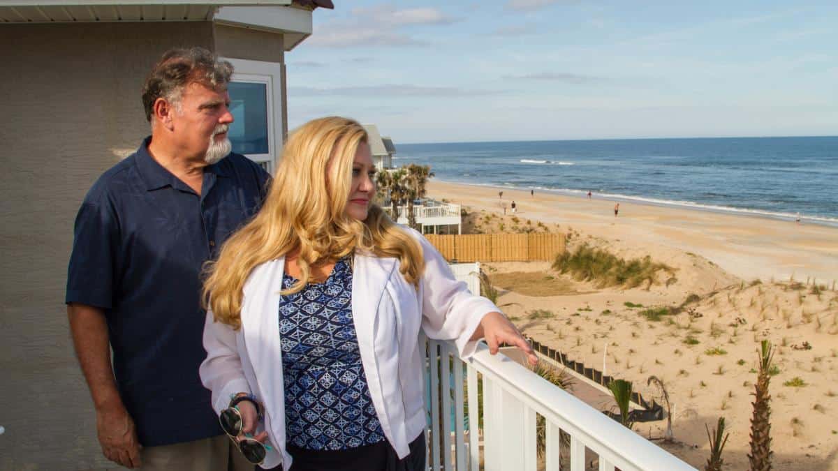 A couple stands on the deck of their new home and takes in the beach view in this image from Pixel Farm