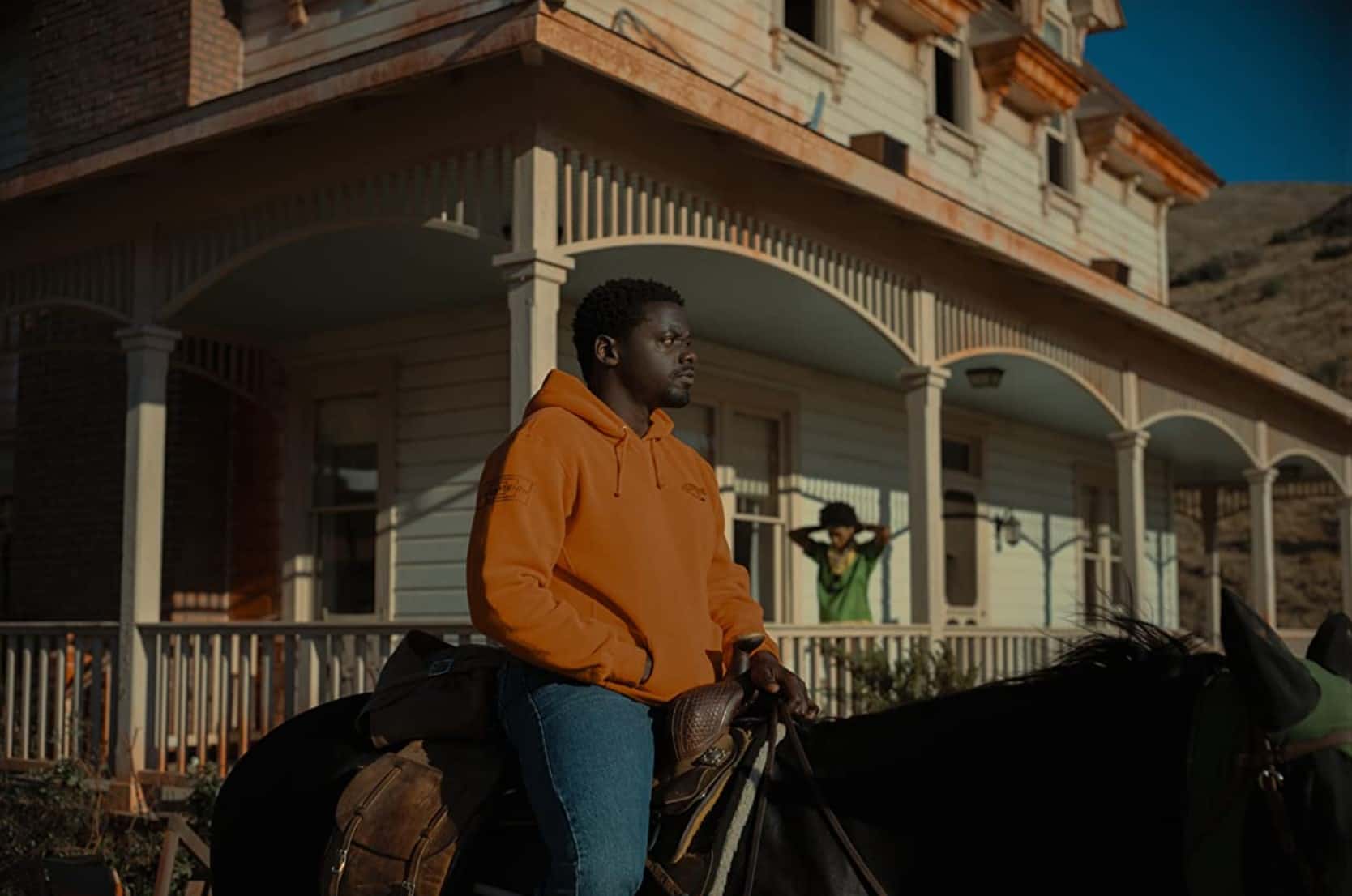 A man sits on his horse outside a house