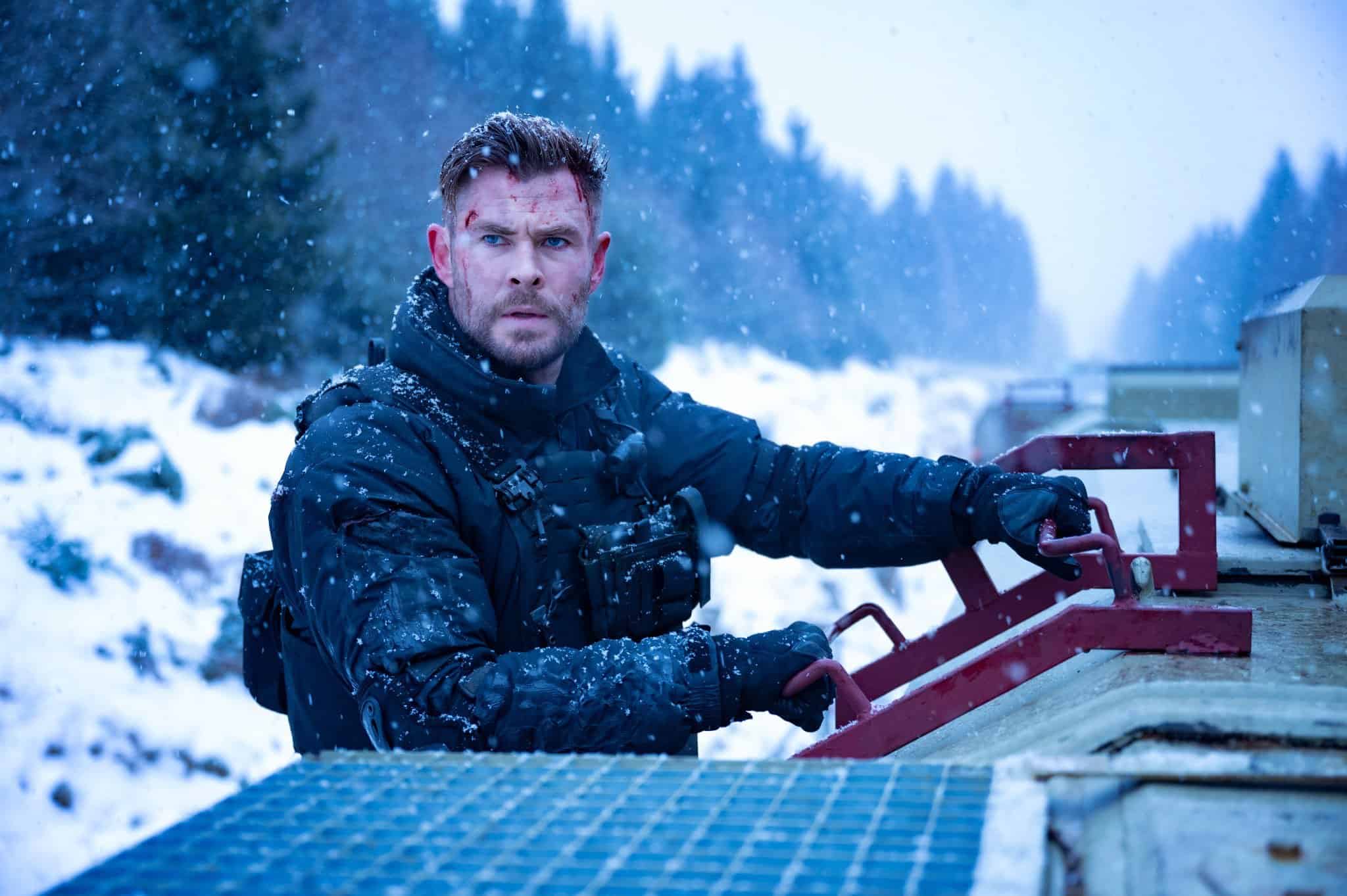 Tyler climbing down a ladder in the snow with cuts on his face