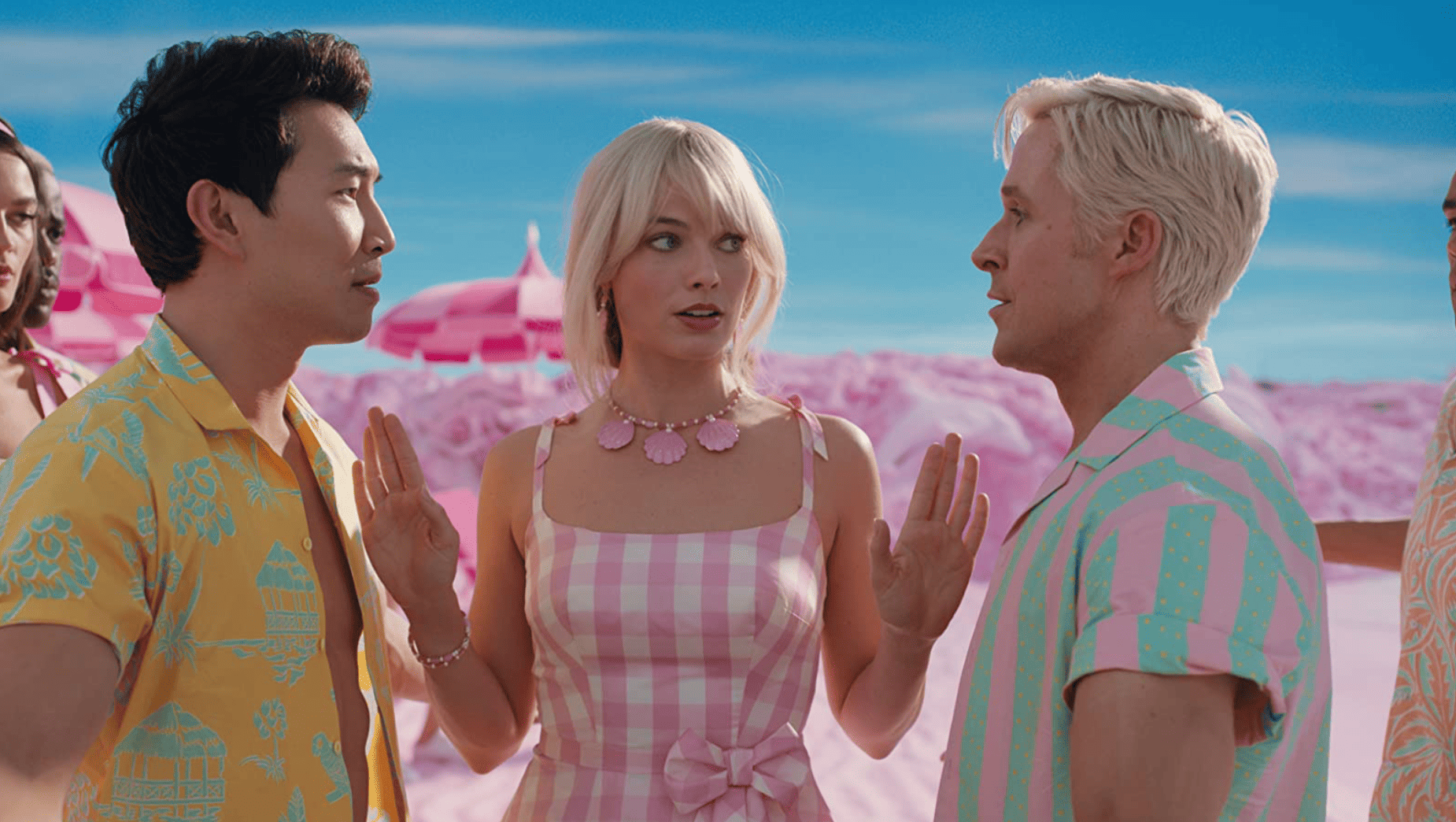 Simu Liu and Ryan Gosling both as Ken facing off against each other and Margot Robbie as Barbie in the middle separating the two with her palms in this image from HeyDay Films